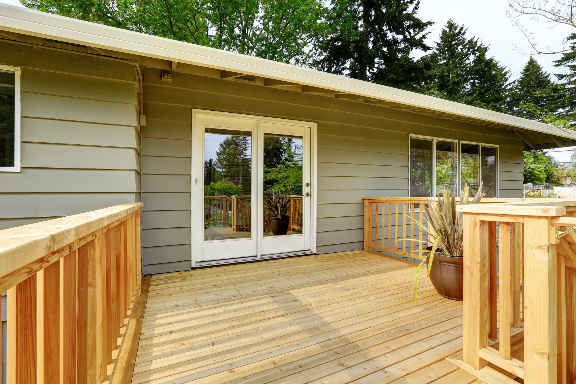 Unstained wood deck with railings and glass doors, deck builders in St. Charles